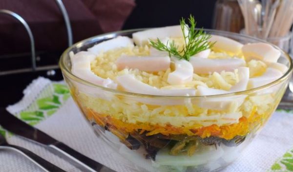 Салат с кальмарами, жареными грибами, сыром и морковью в стеклянном салатнике